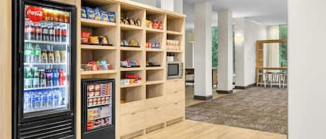 Zona de venta de snacks y bebidas con refrigerador y microondas.