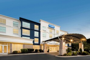 Un hotel con vestíbulo techado, varios pisos y señalización que indica que es un establecimiento Marriott.