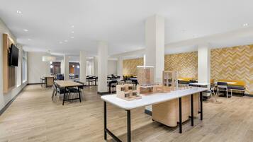 A spacious, modern office with multiple workstations, a central meeting table, and a patterned wall.
