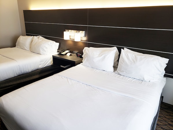 A hotel room with two beds, a nightstand, a phone, and a clock. - Holiday Inn Express Hotel & Suites San Angelo by IHG (San Angelo)