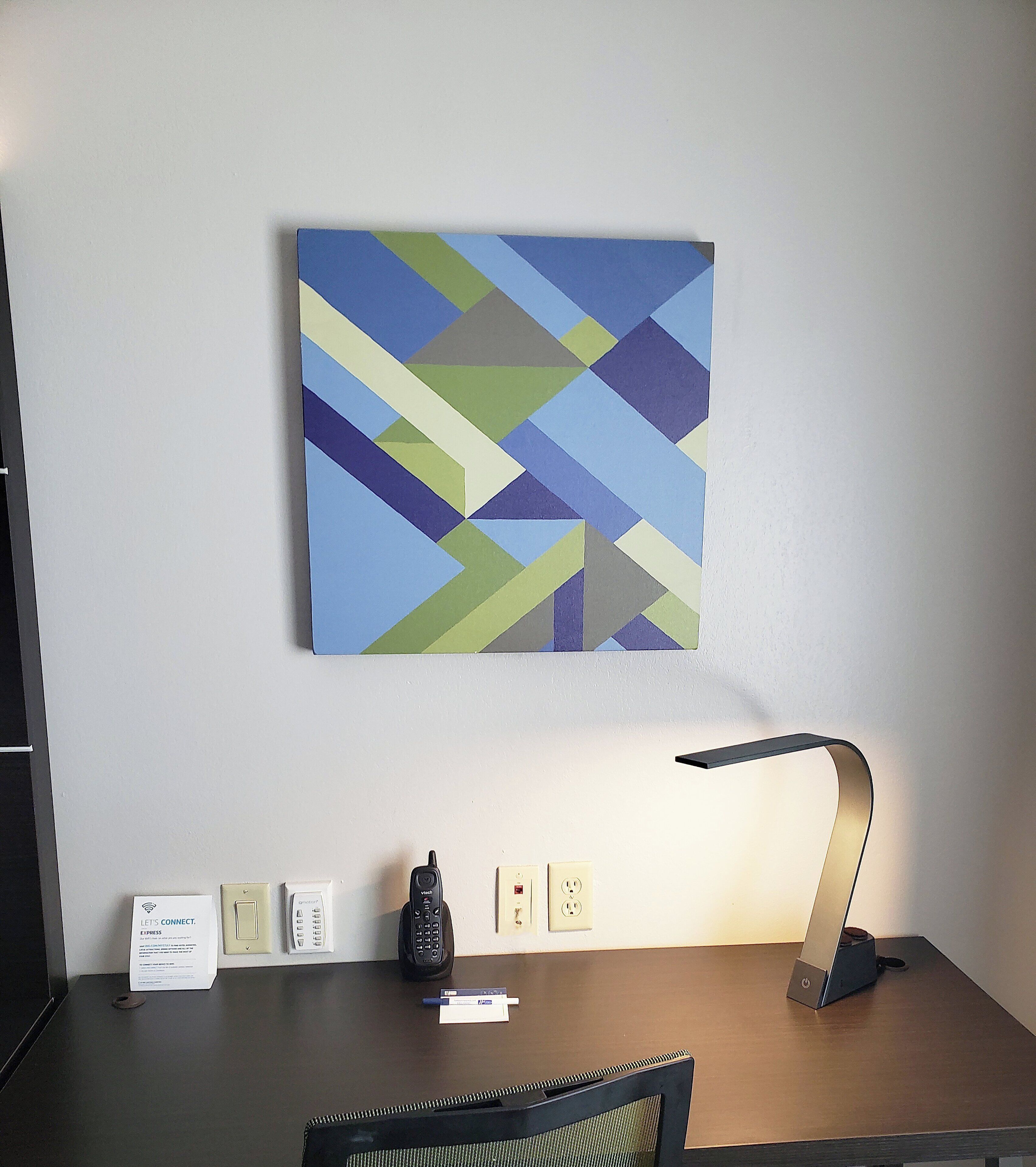 Un bureau d’hôtel avec une lampe de bureau, un téléphone, un bloc-notes et une pancarte sur laquelle est écrit : « Restons en contact ».