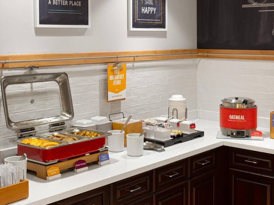 A breakfast buffet setup with various food items and a kettle.