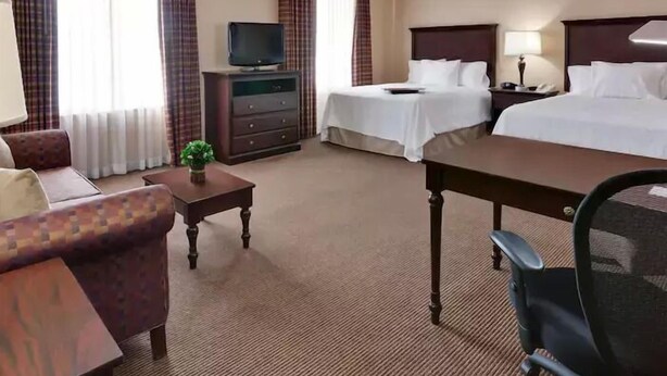 A hotel room with two beds, a TV, a desk, a chair, a lamp, and a dresser. - Hampton Inn & Suites Sacramento-Airport-Natomas (Sacramento)