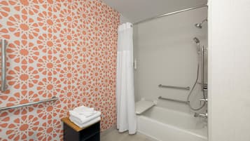 Un baño con ducha, toallero y estante con toallas.
