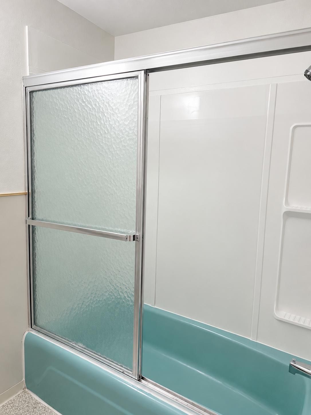 Un baño con cabina de ducha de vidrio y una bañera blanca.