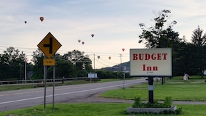 A road sign for Budget Inn with a 'Plant' sign nearby.