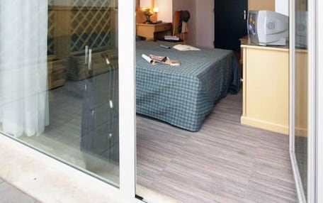 A bedroom with a bed, a desk, a chair, and a wardrobe.