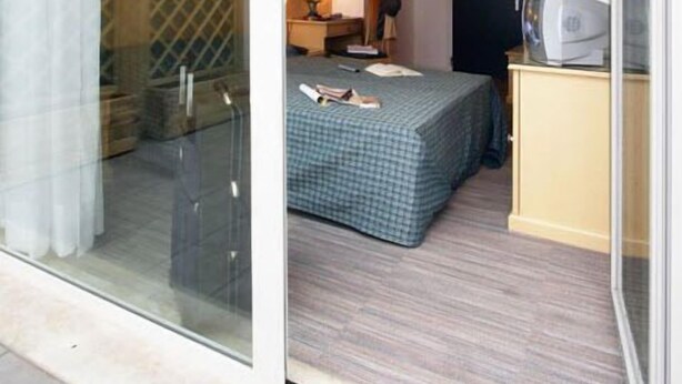 Une chambre à coucher avec un lit, un bureau, une chaise et une armoire.