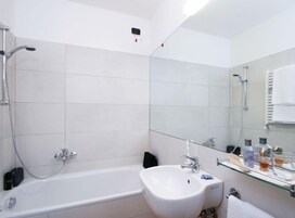 Ein modernes Badezimmer mit einer Badewanne, einem Waschbecken und einer Duschkabine aus Glas.