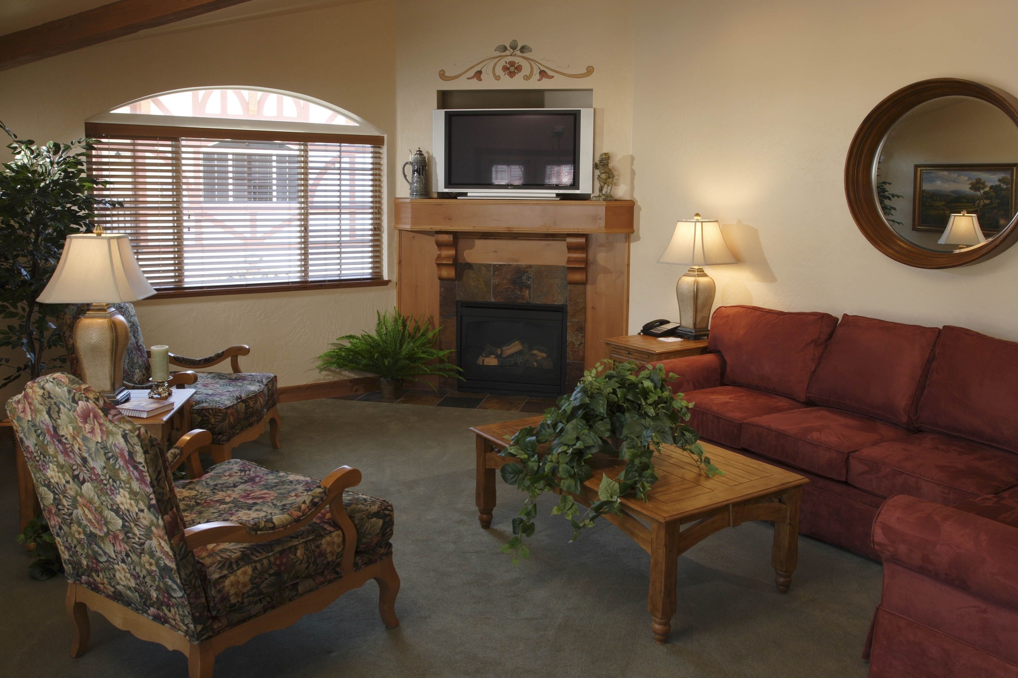 Una sala de estar con chimenea, televisor, sofá y una mesa de centro.