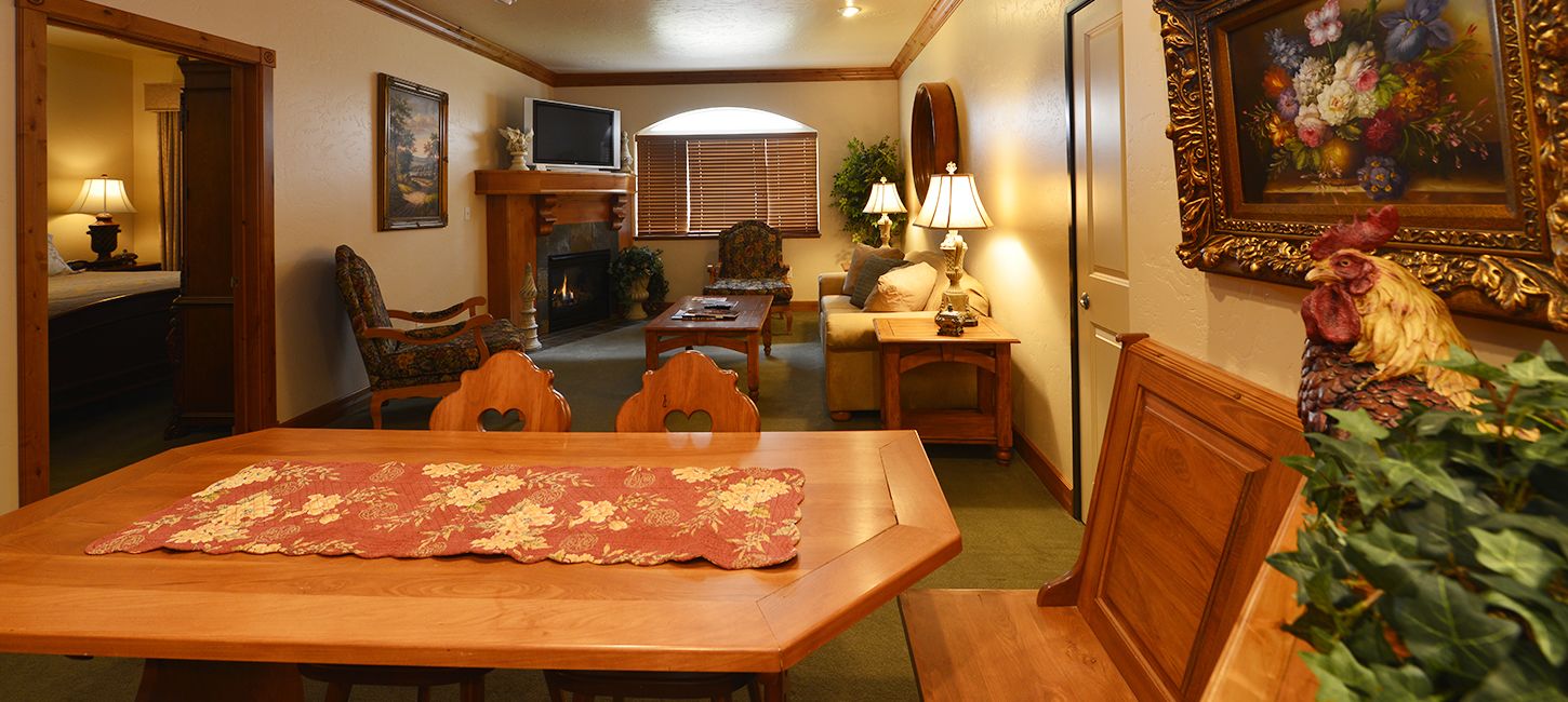 Un comedor con una mesa de madera, sillas, chimenea y televisor.