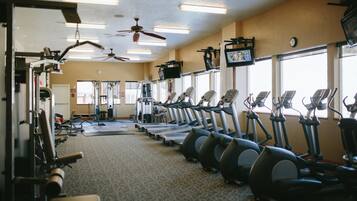 A gym with treadmills, elliptical machines, and weight equipment.