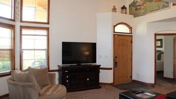 A living room with a television, a sofa, and a coffee table.