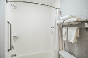 Ein modernes Badezimmer mit begehbarer Dusche, einer Badewanne und einem Handtuchhalter mit ordentlich gefalteten Handtüchern.