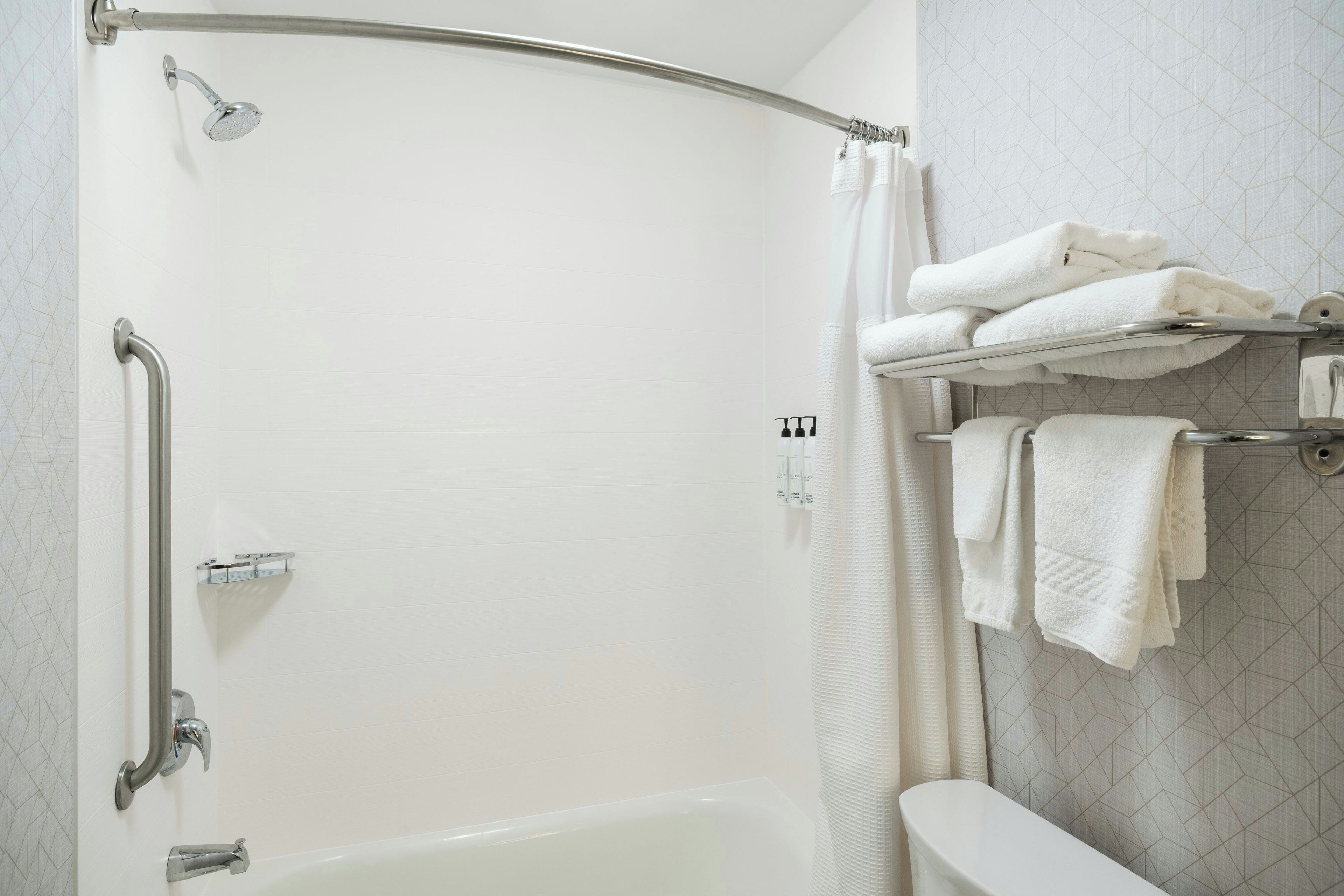 A bathroom with a shower, a toilet, and a towel rack.