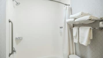 A bathroom with a shower, a toilet, and a towel rack.