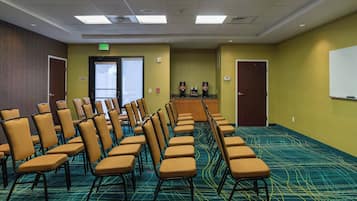 A conference room with rows of chairs, a podium, and a whiteboard.