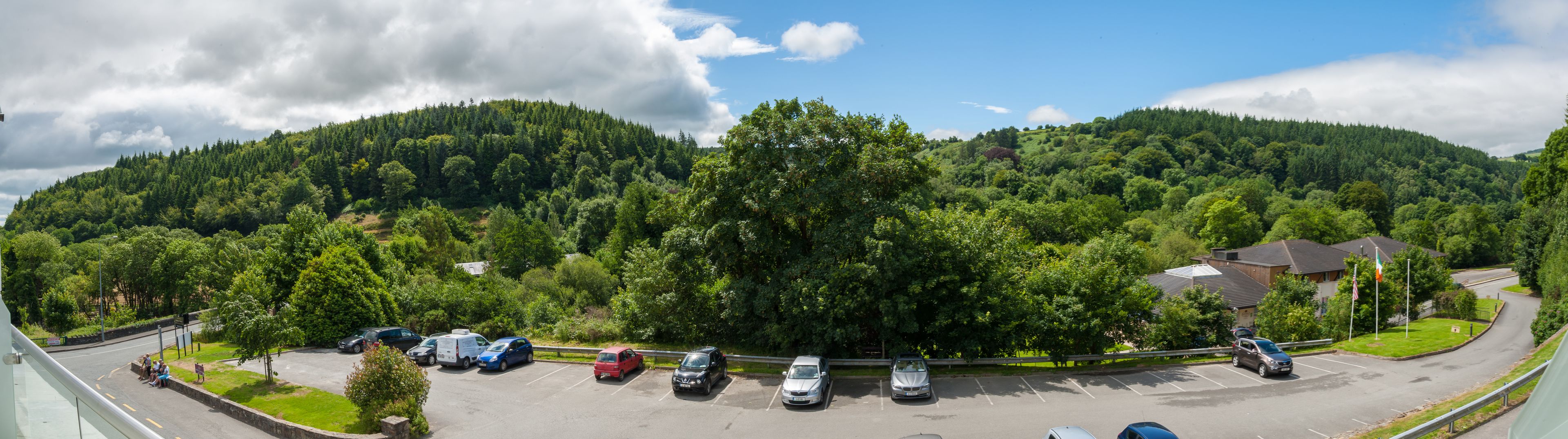 Ein Parkplatz mit mehreren Autos und einem Gebäude mit Satteldach.