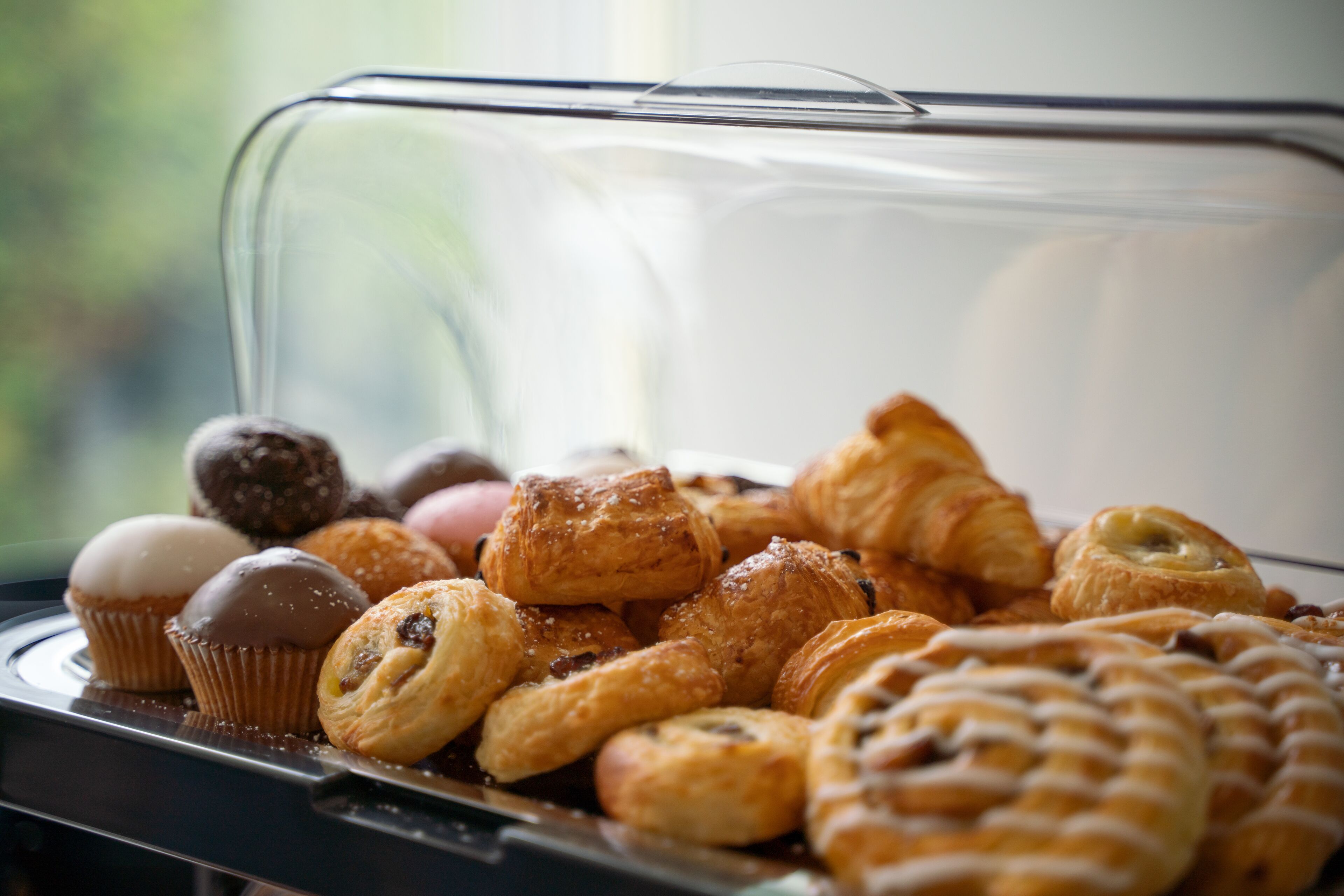 A variety of pastries displayed in a glass case.