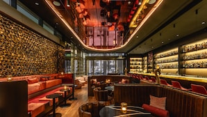 A modern bar area with seating, a bar counter, and a wall of bottles. - Hotel Kö59 Düsseldorf - Member of Hommage Luxury Hotels Collection (Düsseldorf)