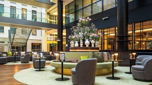 A spacious lobby with a central seating area, multiple sofas, and a large floral arrangement. - Hotel Kö59 Düsseldorf - Member of Hommage Luxury Hotels Collection (Düsseldorf)