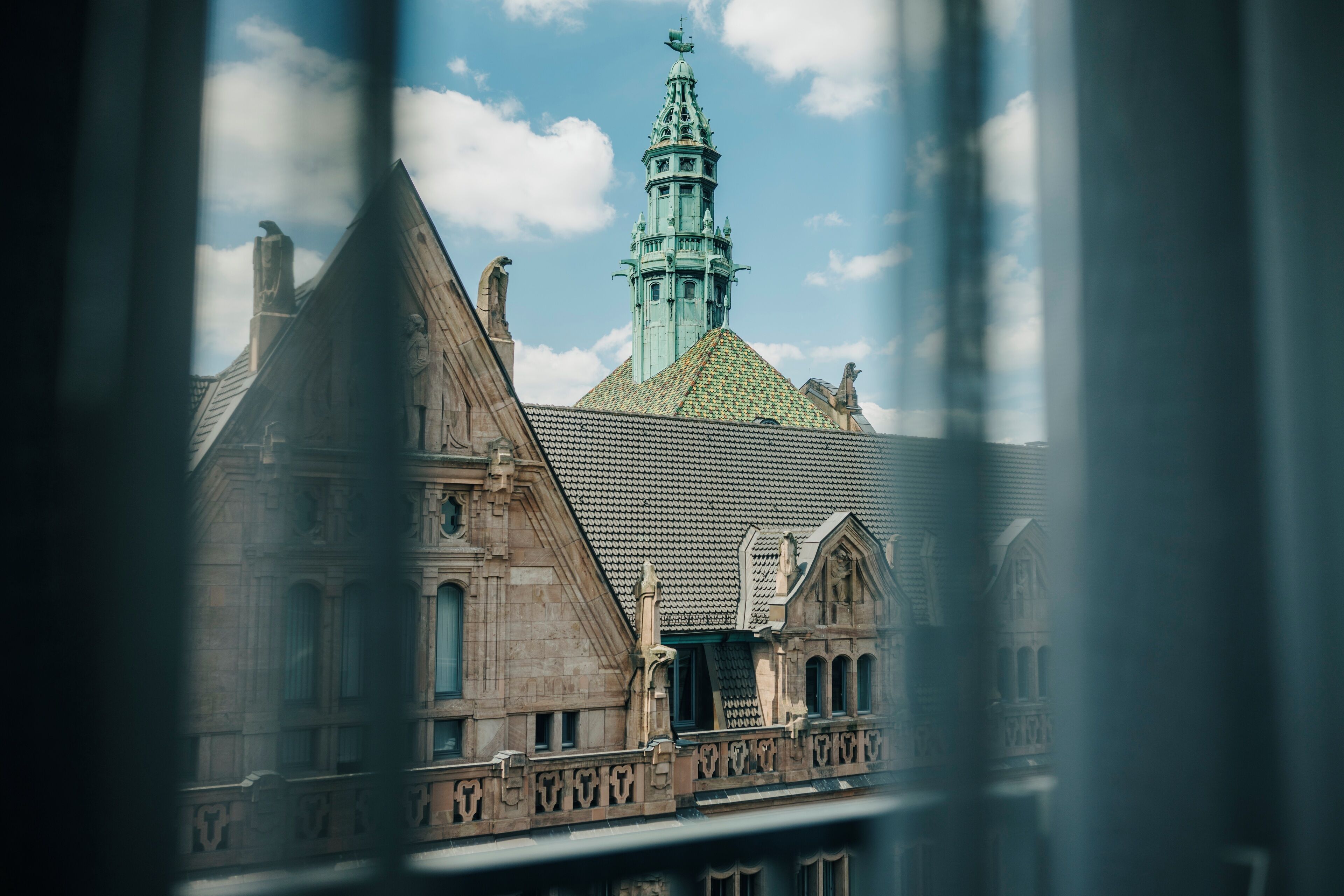 A historic building with a prominent tower and a green roof.