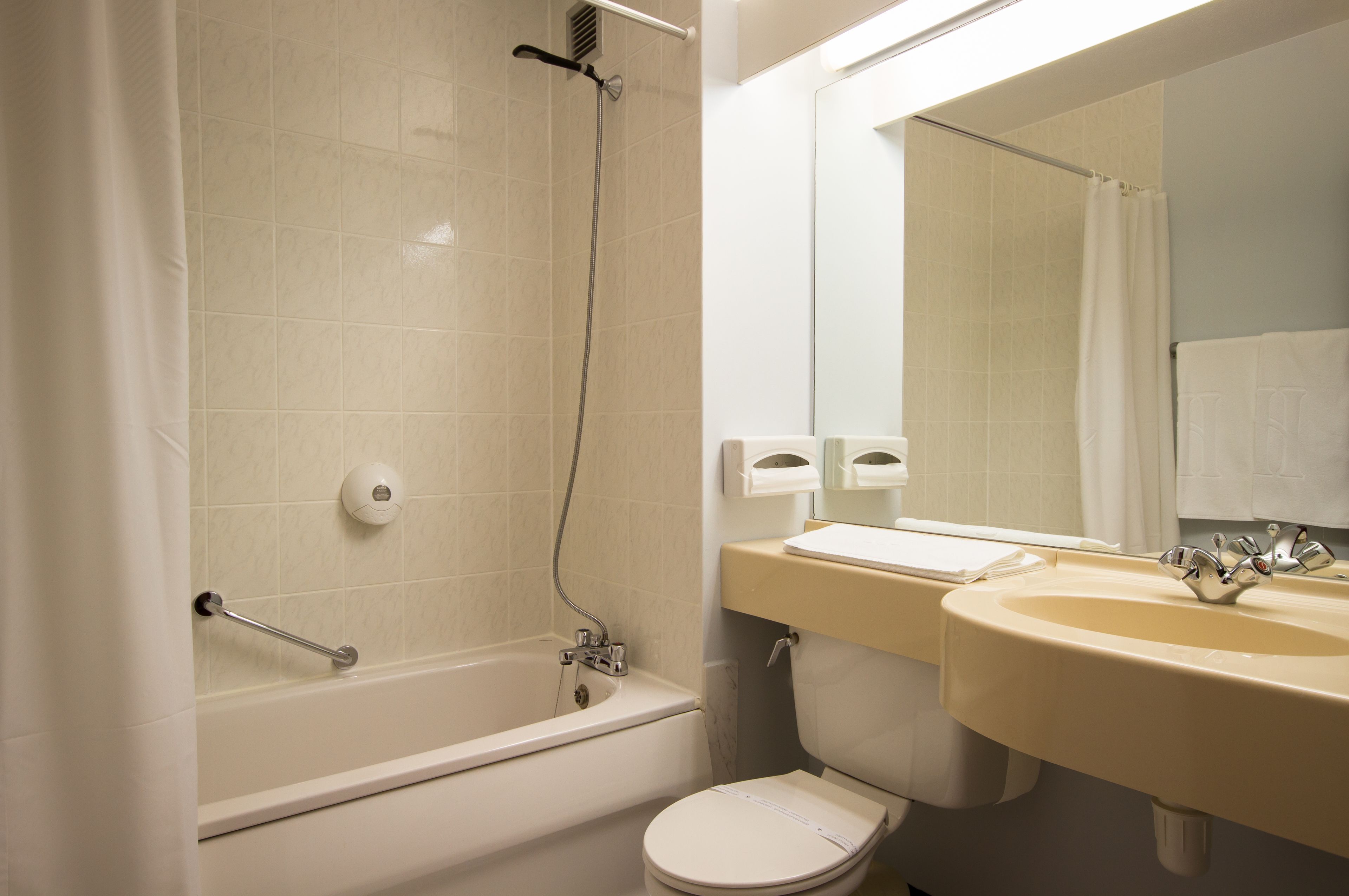 Une salle de bain avec une baignoire, des toilettes, un lavabo et un miroir.
