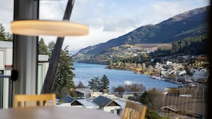 A view from a window overlooking a lake with buildings and mountains in the background. - Scenic Suites Queenstown (Queenstown)