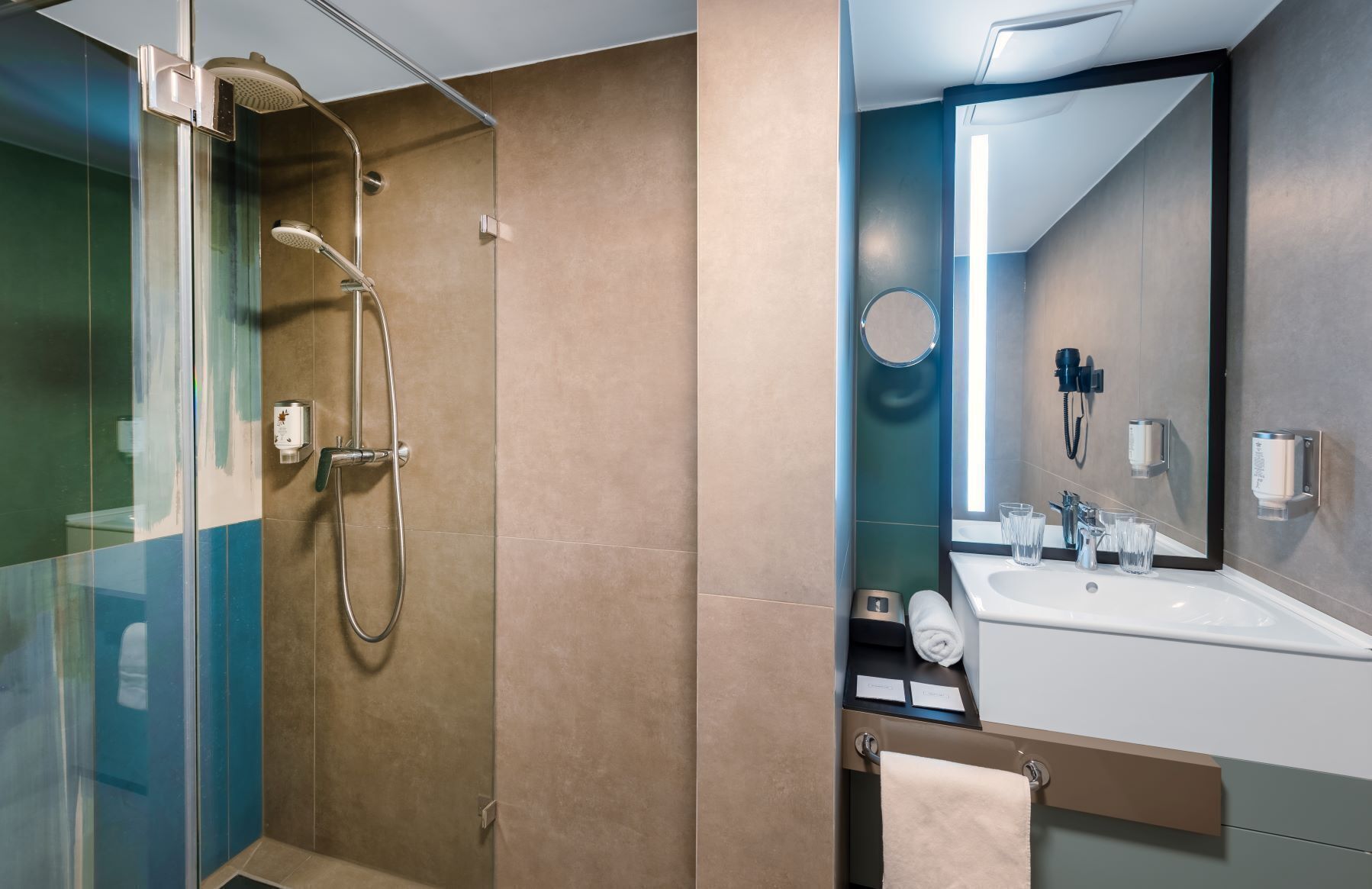 A modern bathroom with a glass shower enclosure, a sink with a mirror, and a towel rack.