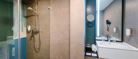 A modern bathroom with a glass shower enclosure, a sink with a mirror, and a towel rack.