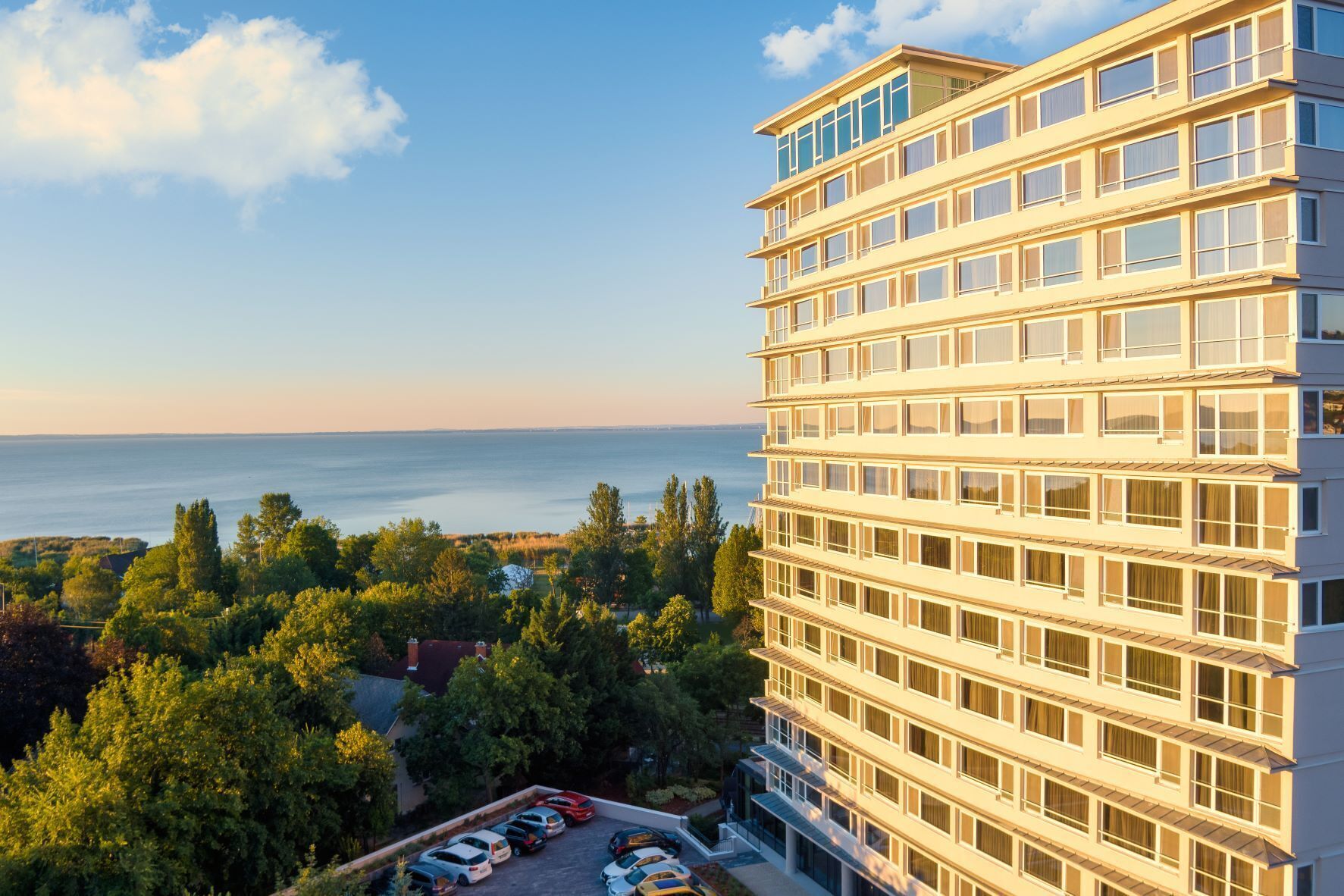 Un hotel de varios pisos con vista al mar y la vegetación circundante.