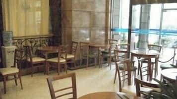 Un comedor con mesas y sillas de madera, ventanas amplias y vistas al exterior.