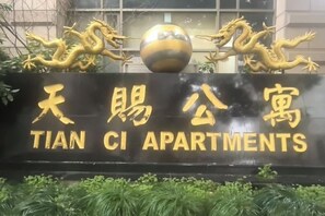 A sign for Tian CI Apartments with a golden dragon and a spherical ornament. - Tianci Service Apartment (Shanghai)