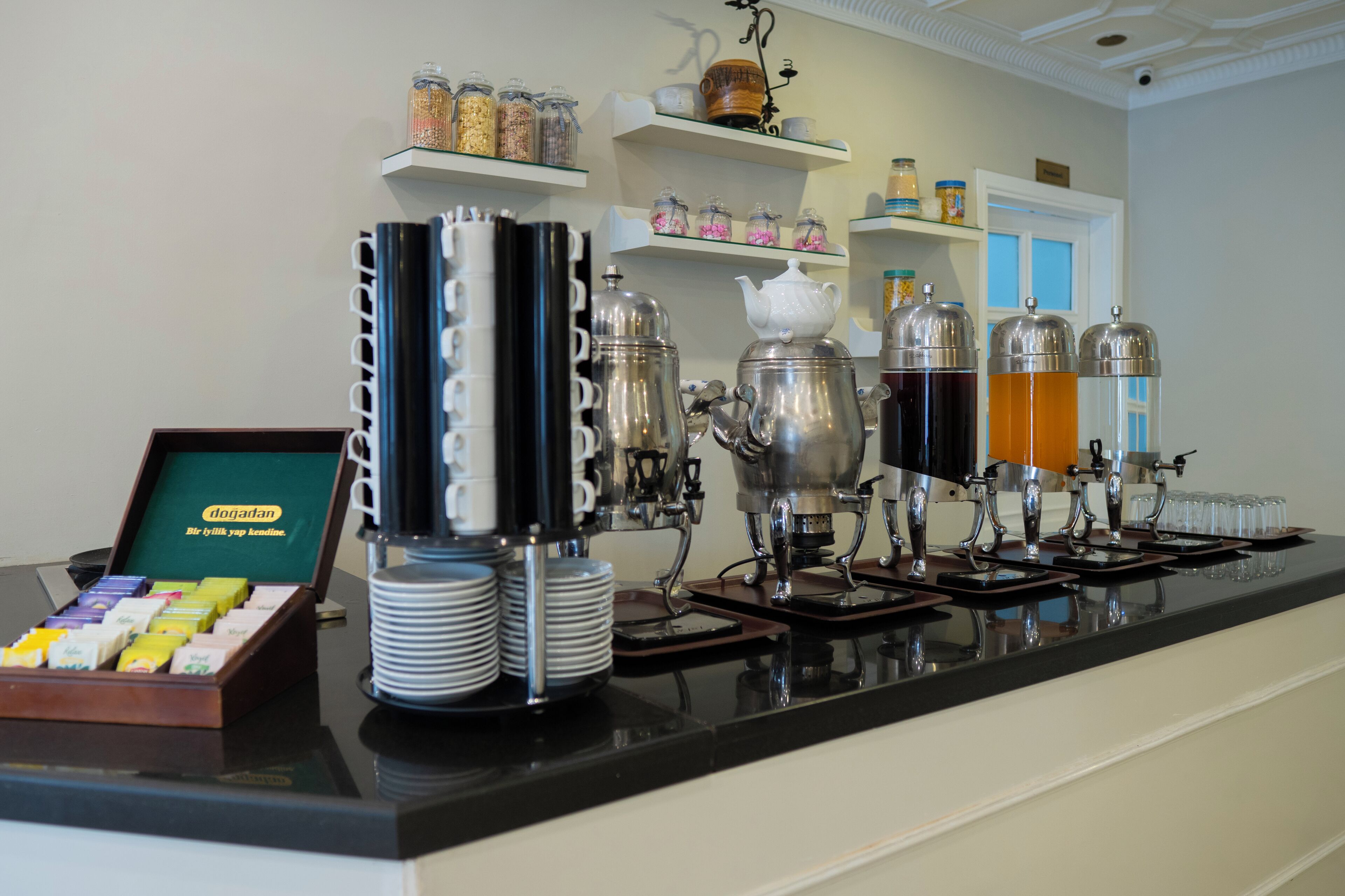Un espace dédié au café, équipé de plusieurs machines à café, d’un assortiment de capsules de café et de différents récipients contenant des condiments.