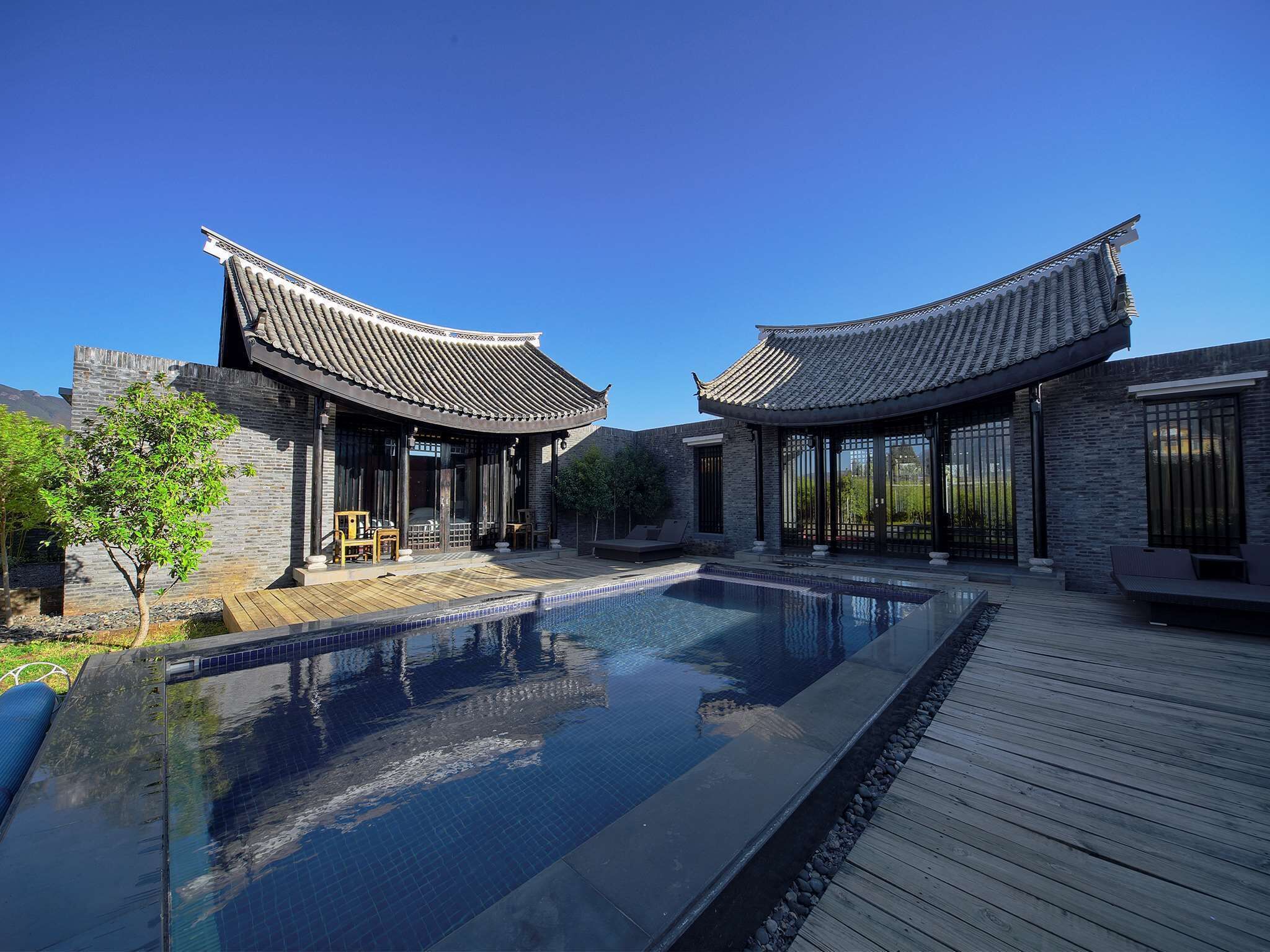 A traditional-style building with a swimming pool and wooden deck.