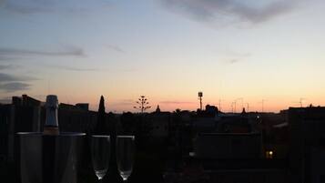 Sonnenuntergangblick mit zwei Gläsern auf einem Balkon.