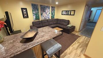 Premium Suite, Multiple Beds | Living area | 24-inch TV with cable channels