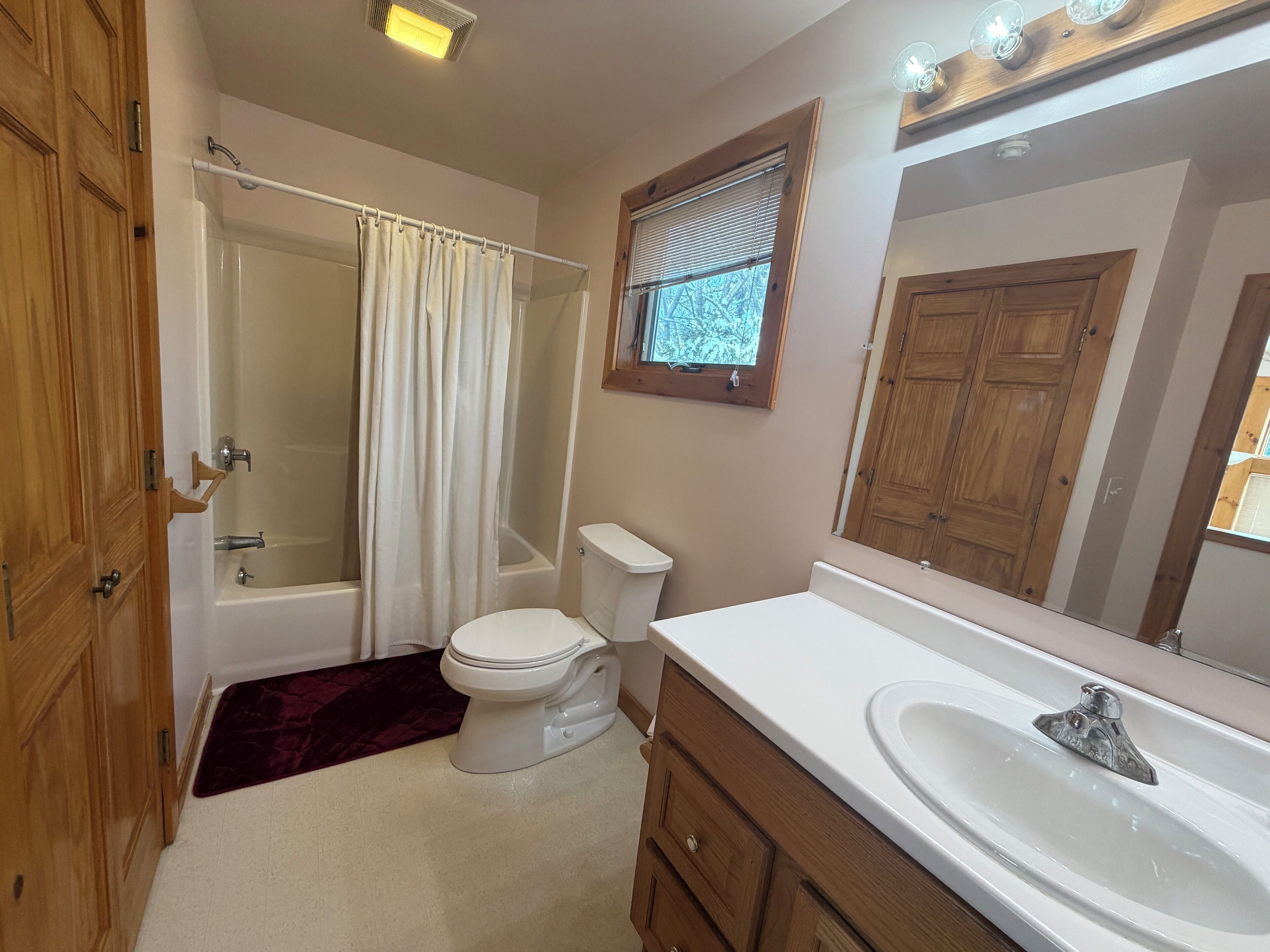 A bathroom with a bathtub, toilet, and sink.