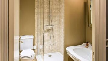 A bathroom with a shower, toilet, and sink.