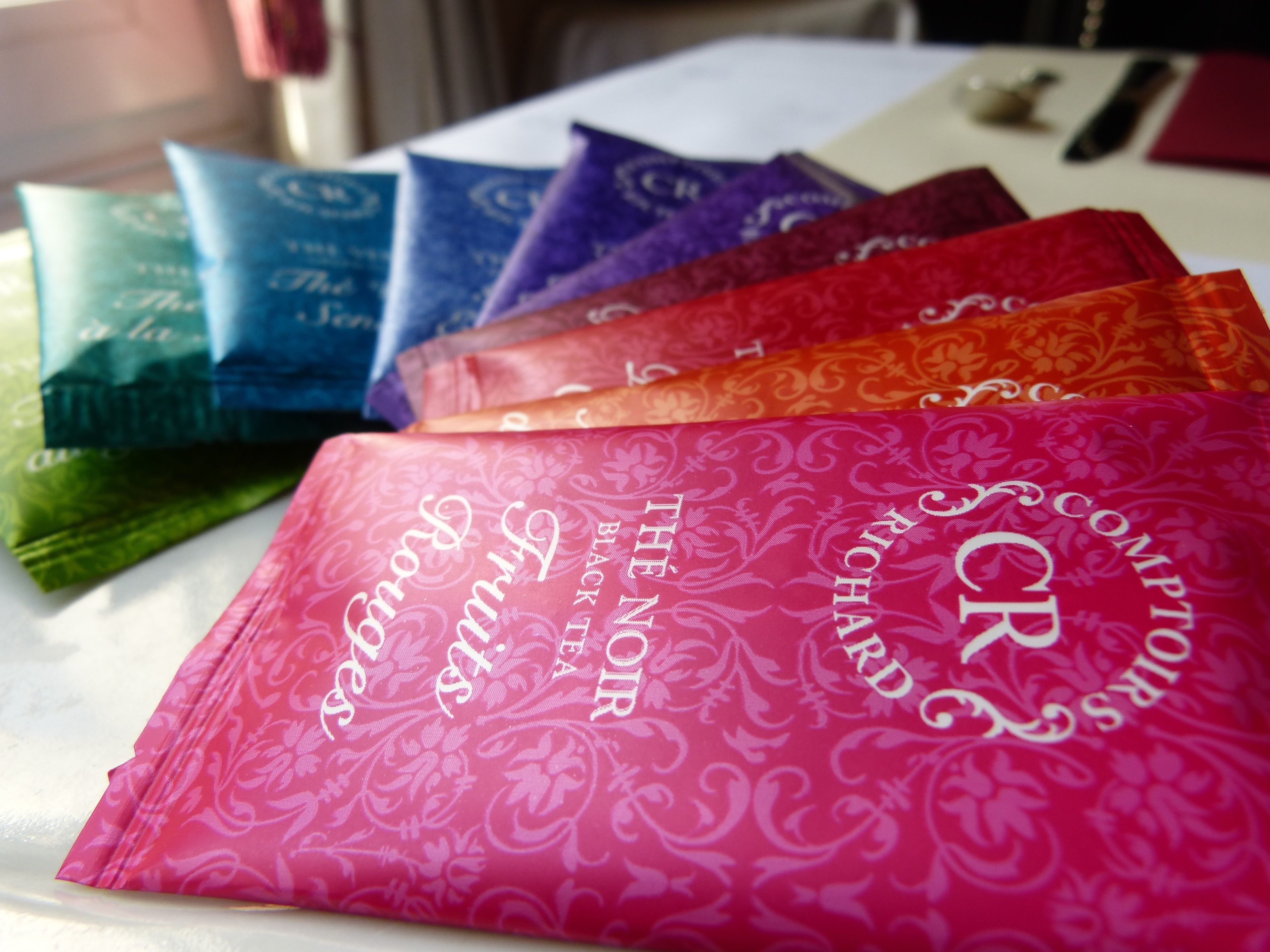 A table with several colorful bags, each with a distinct pattern and text.