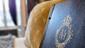 A black leather-bound book with a gold embossed monogram and the words "Hotel Vendôme" on the cover.