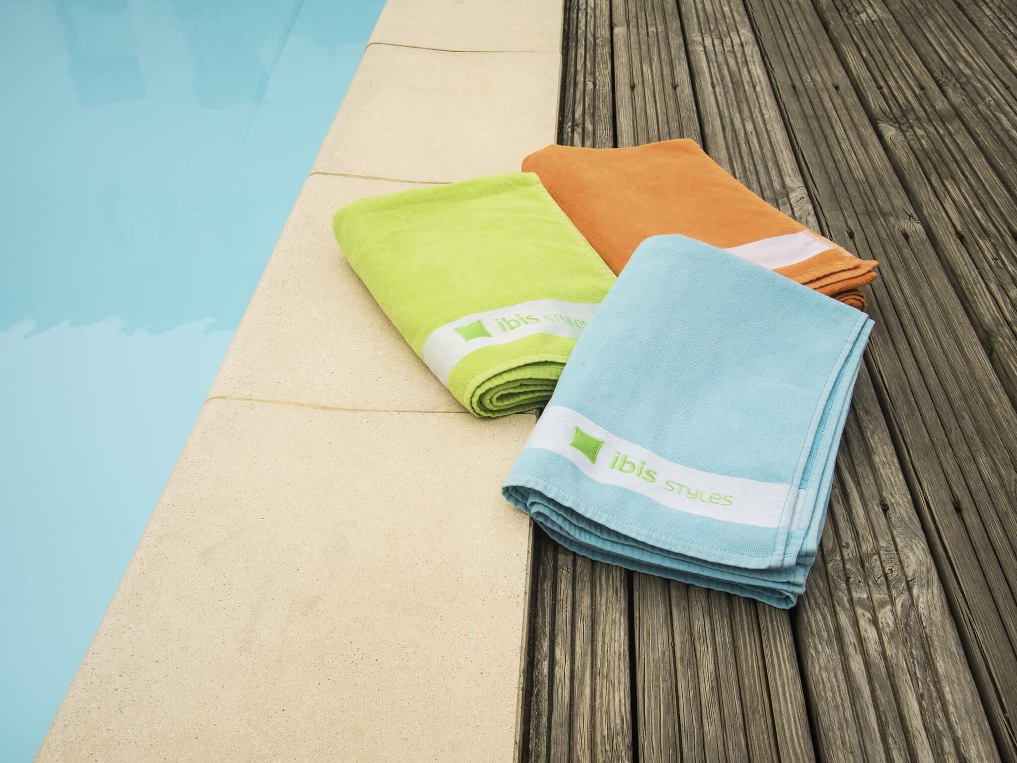 A poolside area with a wooden deck and a pool.