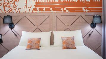 A bed with two pillows, a wooden headboard with a geometric pattern, and two wall-mounted lamps.