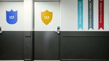 Un couloir d’hôtel avec des portes numérotées 12.3 et 12.5, et des banderoles pour les hôtels ibis Styles, Jours Cathare et Occitanie.