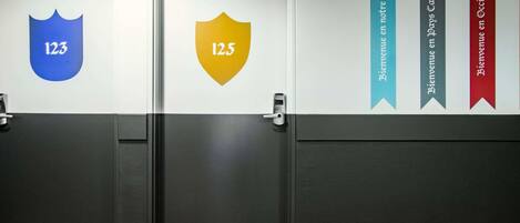 A hotel corridor with doors numbered 12.3 and 12.5, and banners for ibis styles hotel, Jours Cathare, and Occitanie.