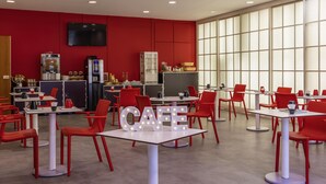 A modern cafe with red chairs and tables, a large window, and a 'CAFE' sign.