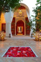 An ornate entrance with a red carpet and decorative lanterns.