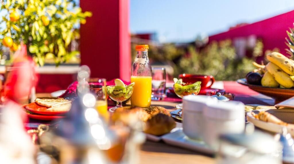 Una tavola imbandita con diversi cibi e bevande, tra cui pane tostato, frutta e una bottiglia di succo d'arancia.