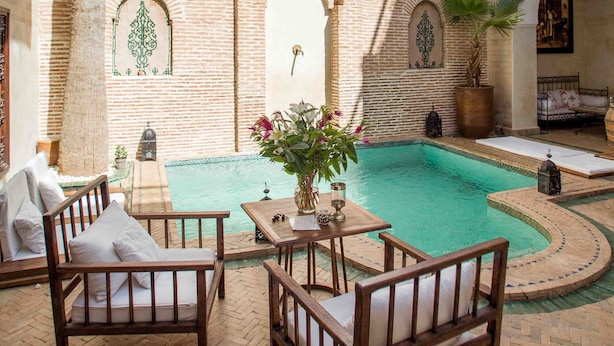 Una piscina al aire libre, sombrillas, tumbonas