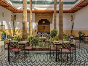 A traditional Moroccan interior with a central fountain, patterned floor, and seating arrangements. - Palais Tinmel Marrakech (Marrakech)